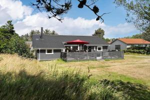 una casa con porche con techo rojo en 1353-Snedsted-Ebenezervej-24, en Snedsted