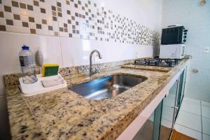 eine Küchenarbeitsplatte mit Spüle und Herd in der Unterkunft Confortável AP próximo ao parque e praias in Penha + 46 Fotos