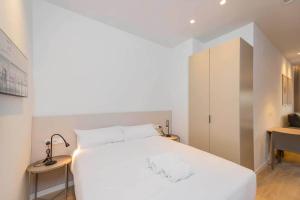 a bedroom with a large white bed and a desk at Stancia Benimaclet - Studio 9 in Valencia