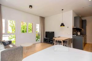 a living room with a white bed and a table at Stancia Benimaclet - Studio 7 in Valencia
