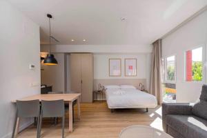 a bedroom with a bed and a table and a couch at Stancia Benimaclet - Studio 7 in Valencia