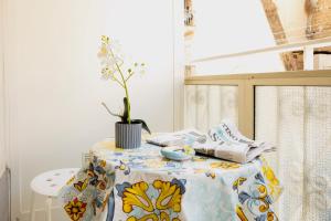 un tavolo con un vaso di fiori sopra di Jordan Apartment a Napoli