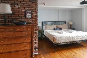 een slaapkamer met een bed en een bakstenen muur bij Gulls' Landing in Provincetown