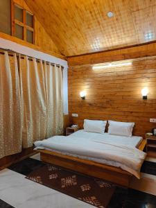 a bedroom with a bed in a wooden wall at Mistymountaincottage in Shimla