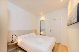 a white bedroom with a large bed and a mirror at Stancia Benimaclet - Studio 1 in Valencia