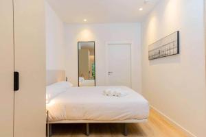 a white bedroom with a bed and a mirror at Stancia Benimaclet - Studio 1 in Valencia +15 photos