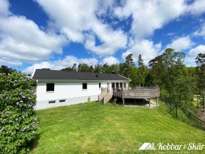 Villa with sauna, 650 m to the beach SE09135 في Sörtegen: البيت الأبيض مع ساحة كبيرة في الأمام