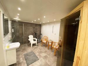 Villa with sauna, 650 m to the beach SE09135 في Sörtegen: حمام مع مغسلة وطاولة وكراسي +25 صورة