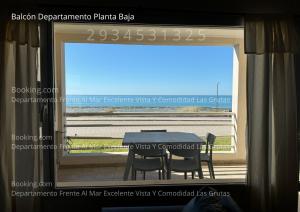 Una ventana con una mesa y sillas en una habitación. en VISTA AL MAR Departamento Frente Al Mar Excelente Vista Y Comodidad Las Grutas, en Las Grutas
