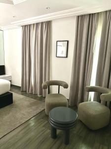 BamgboseにあるHiro Hotelの椅子2脚とテーブルのあるリビングルーム +9枚の写真