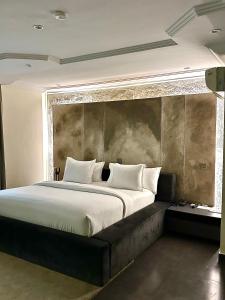 BamgboseにあるHiro Hotelの白い枕が付いた大きなベッドのある寝室