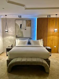 BamgboseにあるHiro Hotelの大きなベッドとベンチグニグニグニグニグニグンのある広い寝室