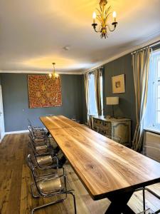 een grote houten tafel in een kamer met stoelen bij Hofensemble nahe Berlin in Lietzen