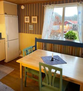 Lovely Cottage near the Resort Nösund SE09111 في Tegneby: مطبخ مع طاولة خشبية ونافذة
