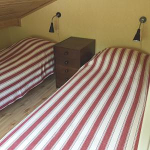 Lovely Cottage near the Resort Nösund SE09111 في Tegneby: غرفة نوم بسريرين توأم وموقف ليلي