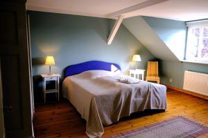 een slaapkamer met een bed en een blauwe muur bij Hofensemble nahe Berlin in Lietzen