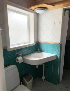 Lovely Cottage near the Resort Nösund SE09111 في Tegneby: حمام مع حوض ومرحاض ونافذة