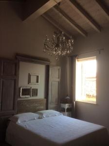 een slaapkamer met een bed met een kroonluchter en een raam bij Appartamento73 in Cignone