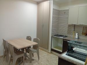 a kitchen with a wooden table and some chairs at Paradise Rose in Sfax