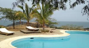una gran piscina con 2 tumbonas y árboles en Vista del Mar Casa y Bungalows en Máncora