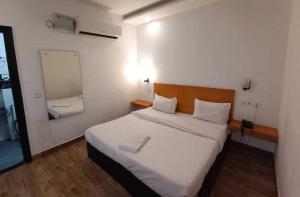 a bedroom with a large white bed and a mirror at Hotel O Sector 18 Dhaliawas Crossway Rewari Formerly Ignis in Rewāri +10 photos