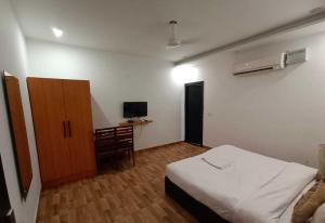 a bedroom with a bed and a cabinet and a television at Hotel O Sector 18 Dhaliawas Crossway Rewari Formerly Ignis in Rewāri
