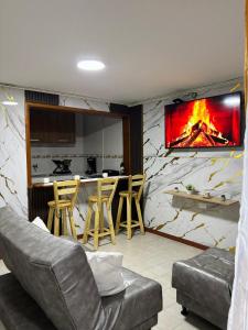 Apartamento cerca al aeropuerto في بوغوتا: غرفة معيشة مع أريكة ومدفأة