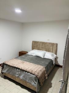 Apartamento cerca al aeropuerto في بوغوتا: غرفة نوم بسرير كبير مع لوح أمامي كبير