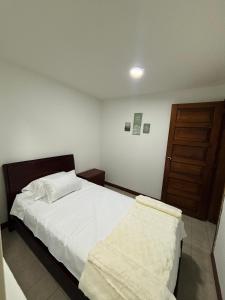 Apartamento cerca al aeropuerto في بوغوتا: غرفة نوم بسرير وباب خشبي +7 صور