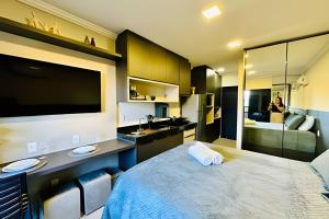 um quarto com uma cama grande e uma pia em Studio Ônix - A poucos passos da Ufu. em Uberlândia