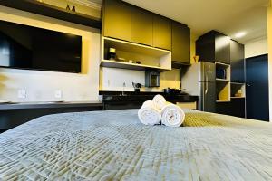 um quarto com uma cama grande com duas toalhas sobre ela em Studio Ônix - A poucos passos da Ufu. em Uberlândia mais 27 fotografias