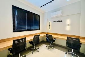 uma sala de conferências com cadeiras pretas e um grande ecrã em Studio Ônix - A poucos passos da Ufu. em Uberlândia