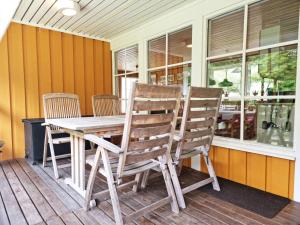 Cottage with Natural Plot and Sauna on Mjörn SE09134 في Dyvik: طاولة وكراسي خشبية على شرفة