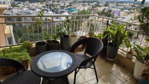 einen Balkon mit einem Tisch, Stühlen und Pflanzen in der Unterkunft Hoysala Ace 1 in Bangalore