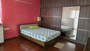 ein kleines Schlafzimmer mit einem Bett und einem Spiegel in der Unterkunft Hoysala Ace 1 in Bangalore