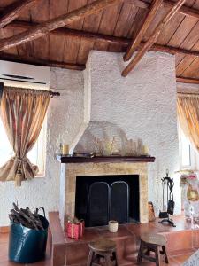 a living room with a fireplace and wooden ceilings at Δωμάτια Εξοχή-With fireplace and view to the sea in Elíki