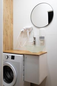 a bathroom with a washing machine and a mirror at Wyjątkowy apartament z prysznicem pośrodku na wyjątkowe wieczory in Łódź