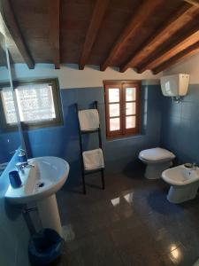 a blue bathroom with a sink and a toilet at Zinfarosa Color Home in Foiano della Chiana
