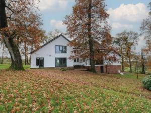 een wit huis met bomen en bladeren op de grond bij Chapel Hill in Penton
