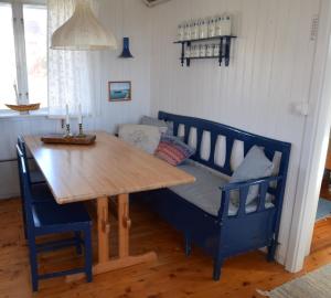 Un comedor con un banco, una mesa y un sofá. en Two charming cottages in Hälleviksstrand SE09133, en Hälleviksstrand