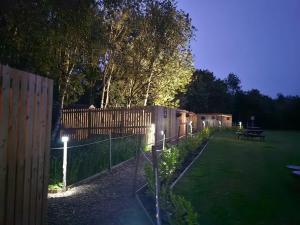 a garden with a fence and a picnic table at night at The Garden in Hambleton