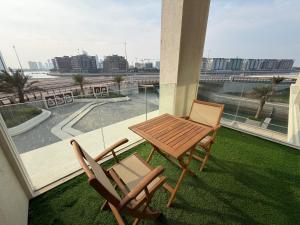 Un patio con una mesa y sillas en un balcón. en Sea View Studio Perfect for Couples In Harbour Row, en Manama