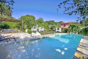 La Casa Fra gli Ulivi luxury apartments with pool near Cinque Terre and Tuscany في مونتيمارتشيلو: مسبح عبارة عن كرسيين بيض في ساحة