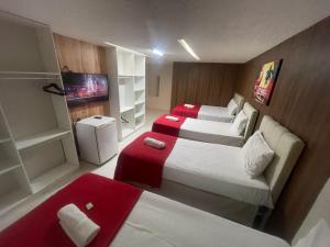 a hotel room with two beds and a couch at Pousada Maré Alta Pajuçara in Maceió