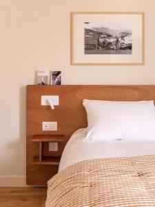 a bedroom with a bed with a wooden head board at Alfred Hotels Paris Gare du Nord- Hôtel Rénové in Paris