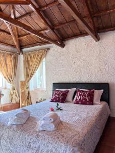 a bedroom with a bed with two towels on it at Δωμάτια Εξοχή-With fireplace and view to the sea in Elíki