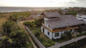 a house on the beach with the ocean in the background at Mambo Ecohostal in San Lorenzo
