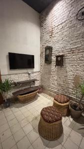 a living room with a tv on a brick wall at A la Gurda Hostel - Barrio Sur in San Miguel de Tucumán