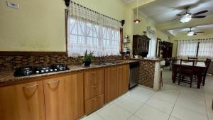 a large kitchen with wooden cabinets and a table at Hostel Ôxe in Paraty