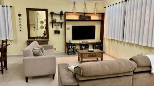 a living room with a couch and a tv at Hostel Ôxe in Paraty +95 photos